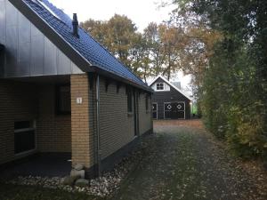 a side view of a building with a garage at De Fugelsang in Jonkersland