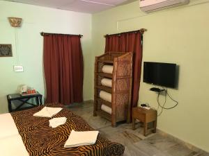 a hotel room with a bed and a television at Baaz Jungle Resort in Khawāsa
