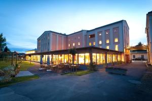 budynek ze stołami i krzesłami przed nim w obiekcie JUFA Hotel Weinviertel - Eselsmühle w mieście Seefeld