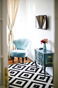 een woonkamer met een blauwe stoel en een tafel bij Andrea Apartments in Cluj-Napoca