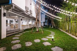 a walkway with lights and grass in front of a building at Your Space Hotel Prasingh in Chiang Mai
