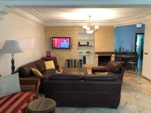 a living room with two brown couches and a tv at Appart 2 Mars Casablanca in Casablanca