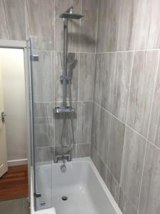 bagno con vasca e doccia di Tapestry Apartment a Londra