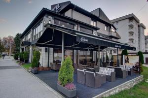 a restaurant with tables and chairs in front of a building at Hotel Zlatna Žita in Pale