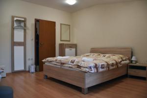 a bedroom with a bed and a wooden floor at Penzión Koruna in Nitrianske Rudno