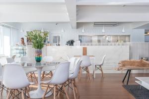 a dining room with a table and white chairs at Hotel Londres Estoril / Cascais in Estoril