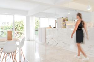 a woman in a black dress walking in a kitchen at Hotel Londres Estoril / Cascais in Estoril