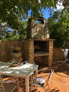 - une table et des chaises devant une cheminée en pierre dans l'établissement La Despensa del Valle, à Restábal