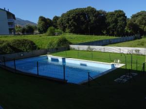 a swimming pool in a field with a fence at Calle Clemente Hernando Balmori nº7 in Llanes