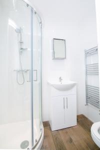 a bathroom with a glass shower and a sink at Earl's Court Studios in London