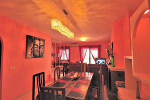 una sala da pranzo con pareti rosse e tavolo con sedie di Chalet H GOLF a Benalmádena