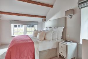 um quarto com uma cama com almofadas brancas e uma janela em The Samling Hotel em Windermere