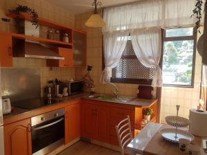 eine Küche mit orangefarbenen Schränken, einem Tisch und einem Fenster in der Unterkunft La Quinta Verde in Santa Cruz de la Palma