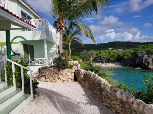 una casa blanca con una palmera y una playa en Alifra Apartment en Lagun