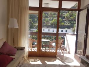 ein Wohnzimmer mit einer Tür, die auf einen Balkon führt in der Unterkunft La Quinta Verde in Santa Cruz de la Palma