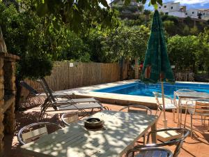 une terrasse avec une table, des chaises et une piscine dans l'établissement La Despensa del Valle, à Restábal