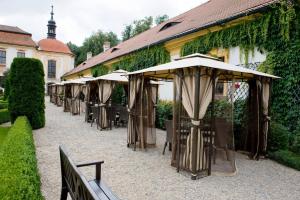 a row of tables with umbrellas in front of a building at Zámek Jemniště in Postupice