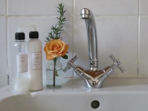a sink with a flower in a vase and a faucet at Modderkloof Farm Accommodation in Paarl +31 photos