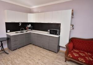 a kitchen with a sink and a microwave and a couch at Guesthouse Ushba View in Mazeri