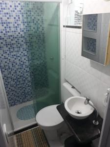 a bathroom with a shower and a toilet and a sink at Arraial Sobradinho in Arraial do Cabo