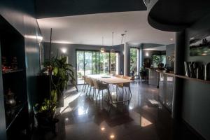 - une salle à manger et une cuisine avec une table et des chaises dans l'établissement La Closerie aux Violettes - Maison d'hôtes, à Toulouse