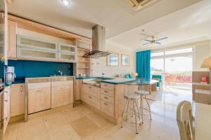 a large kitchen with blue walls and a large window at Holiday Club Playa Amadores in Amadores
