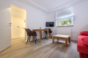 ein Wohnzimmer mit einem roten Sofa und einem Tisch in der Unterkunft Ferienapartments Zwingenberg in Zwingenberg