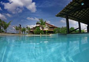 a large blue swimming pool in front of a house at Oceanica 1000 Beachfront Suites in Saquarema