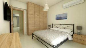 a bedroom with a bed and a flat screen tv at comfy center rodos - luxury in Asgourou