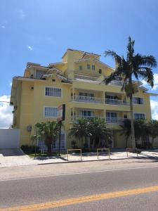 un edificio amarillo al lado de una calle en Apto Jurerê 2 quartos 400m da Praia, en Florianópolis