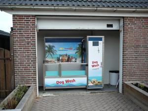 a dog wash window in a brick building at Strandslag Zanddijk 229 Julianadorp aan Zee in Julianadorp