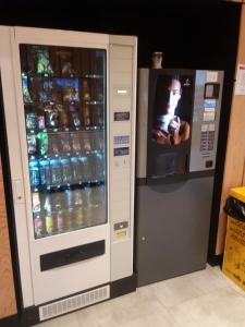 a drink vending machine with a television next to it at Albergue Milladoiro in Milladoiro