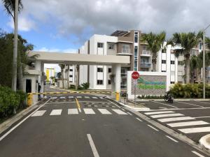 Hato MayorNew Condo Palma Real 3 bd Apt 5 mins from STi的建筑物前面一条空的街道,有停车标志