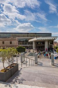 a large building with people sitting outside of it at Your home @Acropolis Museum in Athens