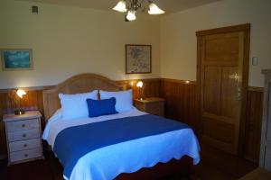 a bedroom with a blue bed with two night stands at Tradicion Austral Bed & Breakfast in Puerto Varas