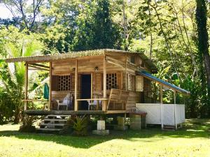 a small wooden house with a porch at Casita del Mar- Caribbean Beachfront Bungalow in Chiquita Beach in Puerto Viejo