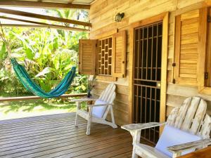 2 sillas y una hamaca en un porche de madera en Villa Mar, en Puerto Viejo