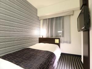a bedroom with a bed and a flat screen tv at APA Hotel Kanda-Eki Higashi in Tokyo