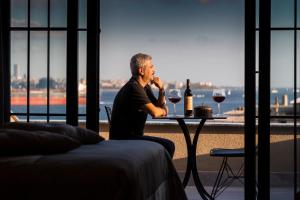 a man sitting on a balcony looking at the ocean at Sublime Porte Hotel in Istanbul