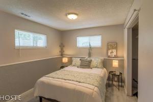 a bedroom with a bed and two windows at 2BR Garden-level Great Outdoors Dog Friendly in Colorado Springs