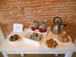 ピエトラサンタにあるAppartamento URANIA - LE MUSEの食べ物とティーポットとペストリーを用意したテーブル