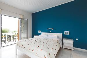 a bedroom with a bed and a blue wall at Panorama Apartments updated with infinity pool in Agios Nikolaos