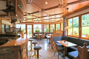 a restaurant with tables and chairs and windows at Hotel Pichlerhof in San Lorenzo di Sebato