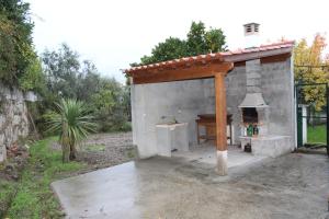 un horno al aire libre con techo de madera en un patio en Casa do Adro en Arcozelo