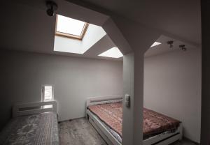 an attic bedroom with two beds and a skylight at Velvet Lazienki Park in Warsaw