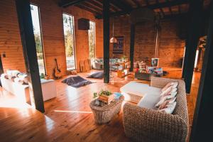 a living room with wicker chairs and a couch at Tripanko Lodge & Bungalows in Pichilemu
