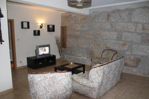 uma sala de estar com duas cadeiras e uma televisão em Casa do Adro em Arcozelo