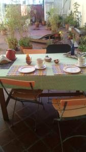 uma mesa verde com pratos e tigelas em Via Arriba B&B em Buenos Aires