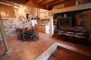 - une cuisine et une salle à manger avec une table et des chaises dans l'établissement Vivienda Vacacional Vila Castriño en las Rias Baixas, à Taragoña