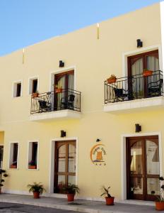 un edificio amarillo con balcones y plantas. en Zingaro Hotel, en San Vito lo Capo